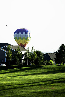 Sun is setting and it appears that the hot air balloon is setting in a residential area.
An image may be purchased at http://edward-peterson.artistwebsites.com/featured/balloon-house-edward-peterson.html