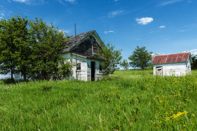 The one room schoolhouse started the education process in this country. Some of these buildings still exist today having been returned to the farm where the land was donated. They became another farm building. The one on the farm I grew up on was used to raise chickens and we roller skated in it. As you drive the country roads they are easy to spot. You will find a one room building off by itself between a couple of farms. Often time the coal shed is still standing. If the buildings are gone you can still spot where there was a schoolhouse and it is a small section of land, with a driveway from the road and a lot of time it is fenced in. Also, there are usually trees enclosing the section. This school was found in Cass County Iowa. I haven't been able to find out the name of the school from looking at old plats of the country.

An image may be purchased at http://edward-peterson.pixels.com/featured/country-school-edward-peterson.html?newartwork=true