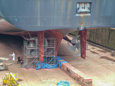 Workers under a big ship
