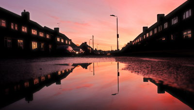 A Lynton  Avenue  dawn , reflected  in  a  puddle.