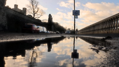 Rochester  Castle  walls  ,reflected  in  a  puddle.