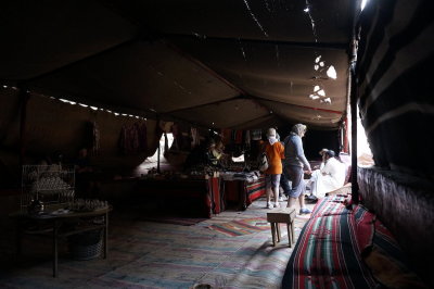 inside a bedouin merchant's tent, an Italian tour group bargains...