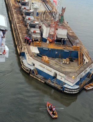 THEY USE ROW BOATS TO TAKE GUIDE LINES TO THE SHIP - SAFER, MORE RELIABLE