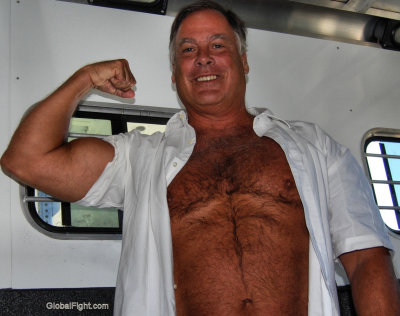 gay older man flexing massive biceps.jpg