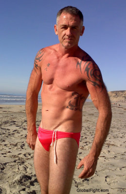 muscleman posing beach sandy resort.jpg