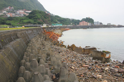 Coastline with wave breakers. The orange ones are made of metal and are oxidizing.