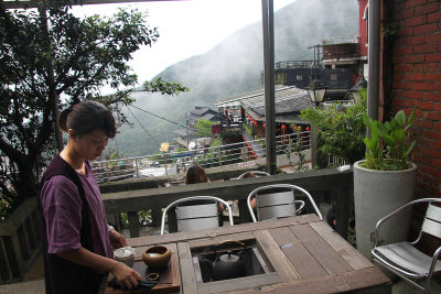 A woman serving tea at the tea house.