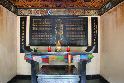 Small alter with Buddhist statue and candles.