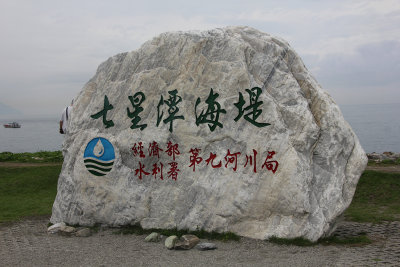 Rock with Chinese writing and a logo in Stone Sculpture Park.