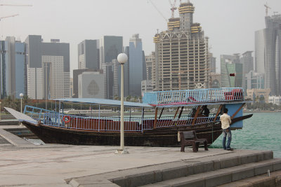 A nearby passenger boat with the Doha skyline in the background.