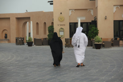 A typically-dressed couple walking by.