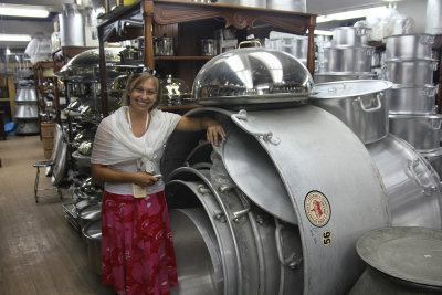 My tour guide, Sylwia, standing next to huge pots in a kitchen shop.