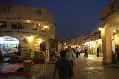 People walking through the souq at night.