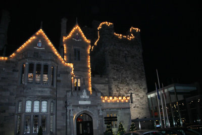 Exterior view of Clontarf Castle with Christmas lights lit up at night.