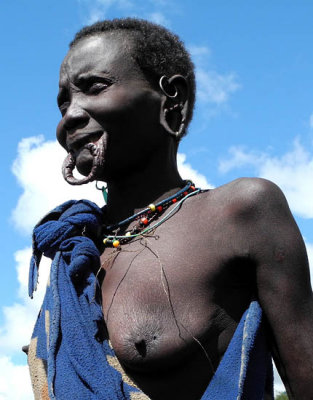Surma woman with streched lower lip and stretched ear lobes for plates;  south-western Ethiopia.