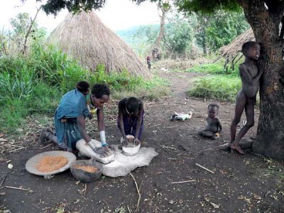 Surma woman and her daughter grinding maize; south-western Ethiopia.