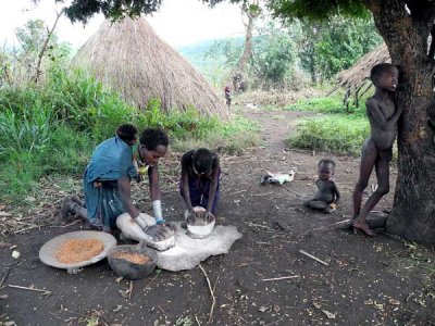 Surma woman and her daughter grinding maize;  south-western Ethiopia.