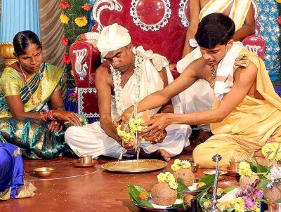 The waters of two coconuts are poured together on a plate by the brides father; wedding ceremony in Karnataka, India