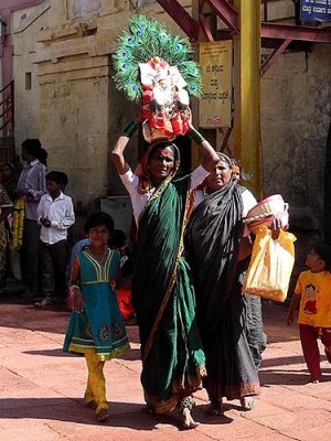 Devotee carrying a basket containing a brass bust of Yellamma, Yellamma temple,  Saundatti, Karnataka, India