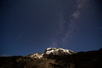 Perseid meteor on the left, with the Milky Way extending from behind the Kili summit.