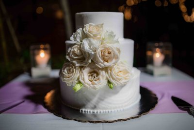 Clean elegant wedding cake with cream florals. Photo by Cecilia Dumas