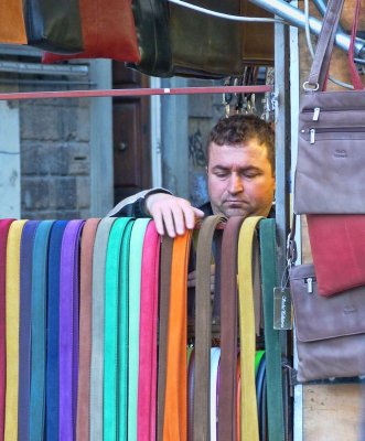 One of the leather sellers displays his multicoloured belts....