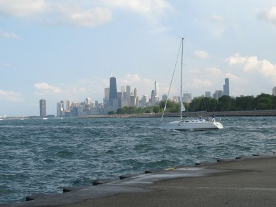 Sailboat heading out with downtown in the background