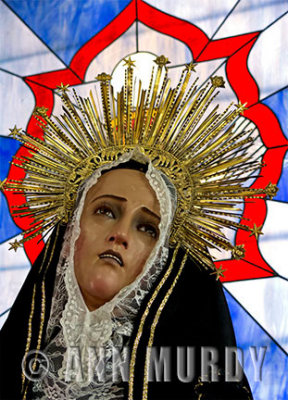 Madre Dolorosa in front of stained glass