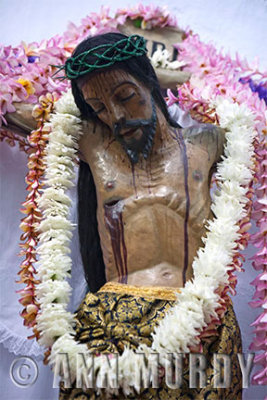 Cristo with leis of flowers