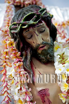 Cristo covered with leis of flor de mayo