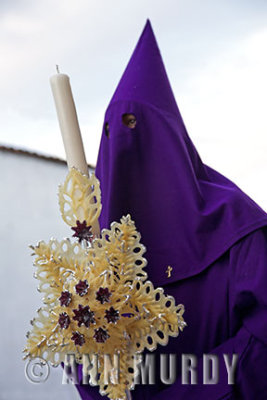 Penitente holding candle in procession