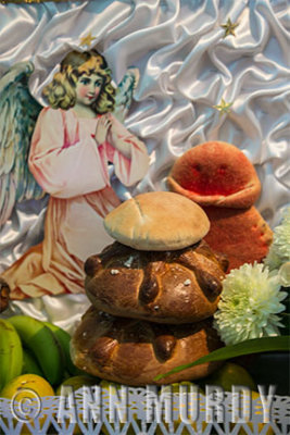 Angel with pan de muerto and fruit