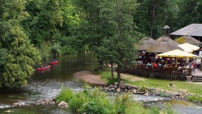 Kayaking on River Vilna past restaurant in Belmontas Park, outskirts of Vilnius