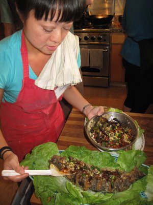 Claudine plating Kitchen Garden Fish  Crisp-Fried and Dressed in a Tart Sauce with Fresh Herbs, Diced Lime, Cashews and Crisped Shallots (Bplah Chon Chom Suan)