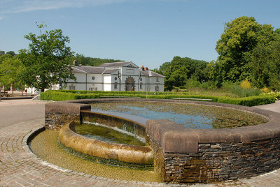 The waterfall, showing the old stable block.  Now the shop and Cafe'