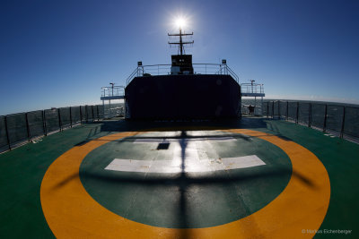 standing on the helipad of the ship and enjoying the sun