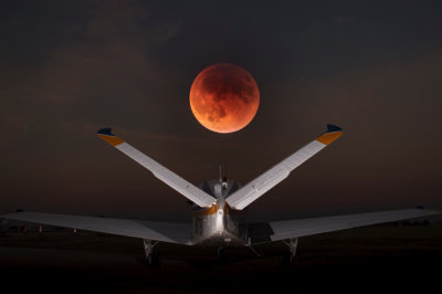 An eclipsed moon, September 2014, and a Beech Bonanza in a composited image.