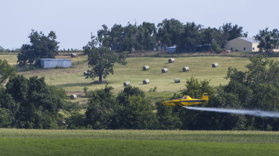 Crop Duster with Hay Bales in Background