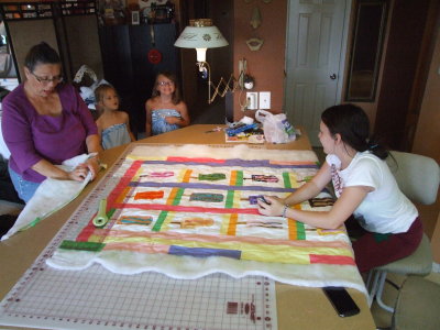 Bachi showing the girls how to quilt