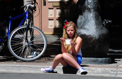 Girl eating ice cream waiting for the July 4th Parade