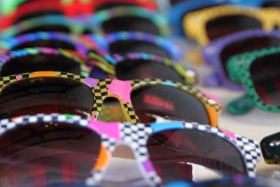 Sunglasses for sale at a sidewalk display.