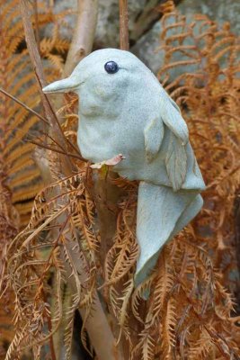 A ceramic bird with fall ferns