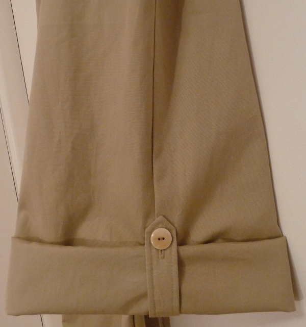 The buttoned tab holding the rolled leg