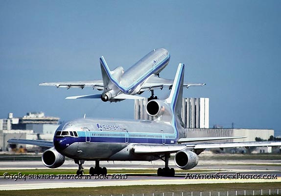 1984 - Eastern Airlines Lockheed L1011-385 N318EA taxiing out for takeoff as another Eastern L1011 takes off from runway 9-left