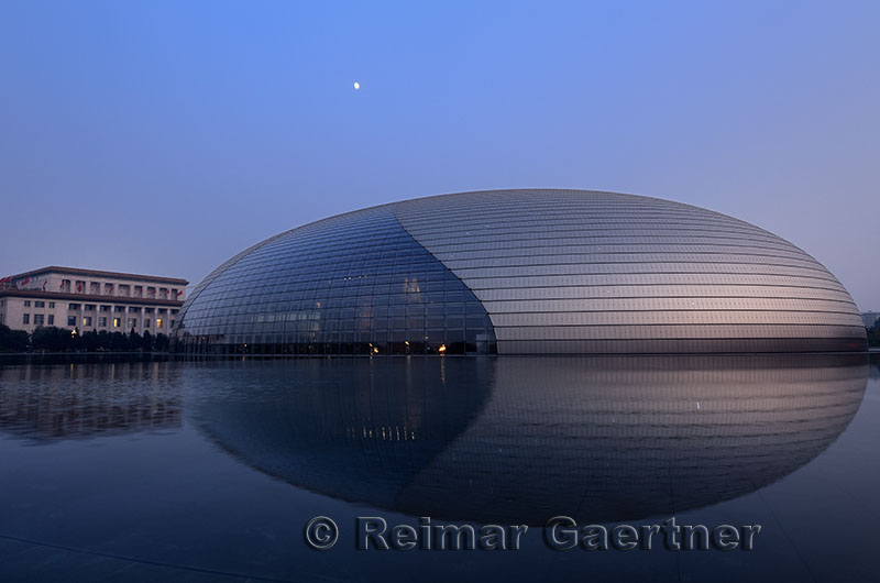 National Centre for the Performing Arts egg at dusk with moon and Peoples Congress in Beijing