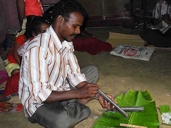 Kani shamanism. Before the ceremony grains of rice are poured down the kokkara. Tirunelveli District, Tamil Nadu.