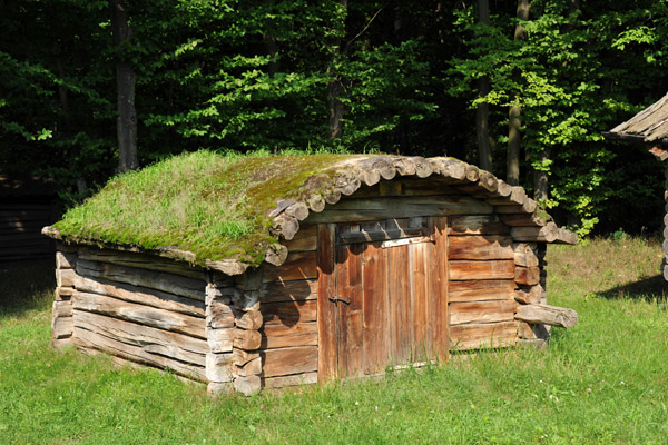 Small log storage hut with sod roof on logs, Pyrohiv Museum of Folk Architecture
