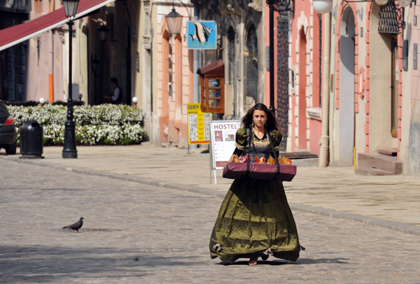 Woman in old fashioned clothing selling candy on Rynok Square, Lviv