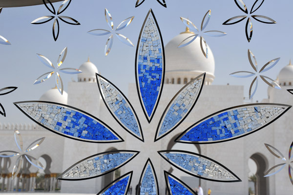 Glass mosaic artwork inlaid in a window continuing the flower motif