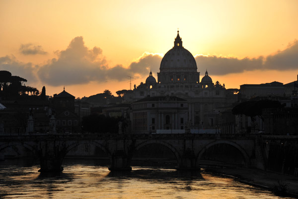 The sun disappears behind the dome of St. Peter's Basilica